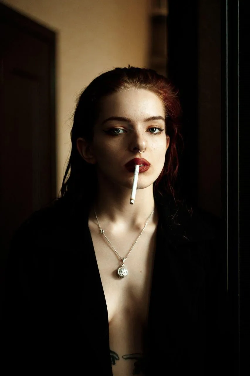 Mysterious woman in a black coat posing in a soft warm light