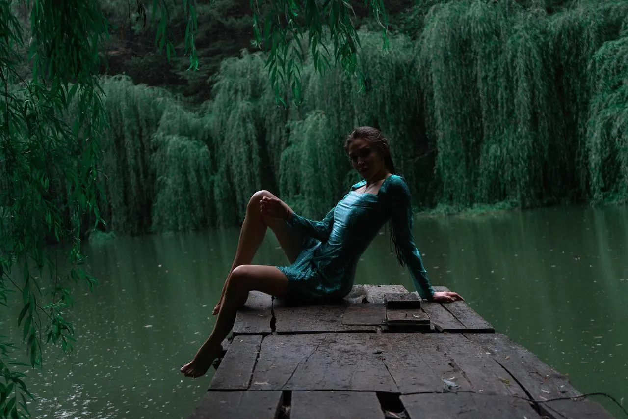 Peaceful Lakeside Scene with Woman Sitting on Wooden Dock