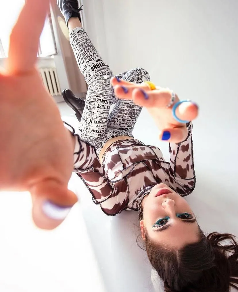 Playful woman lying down with a printed outfit HD Wallpaper