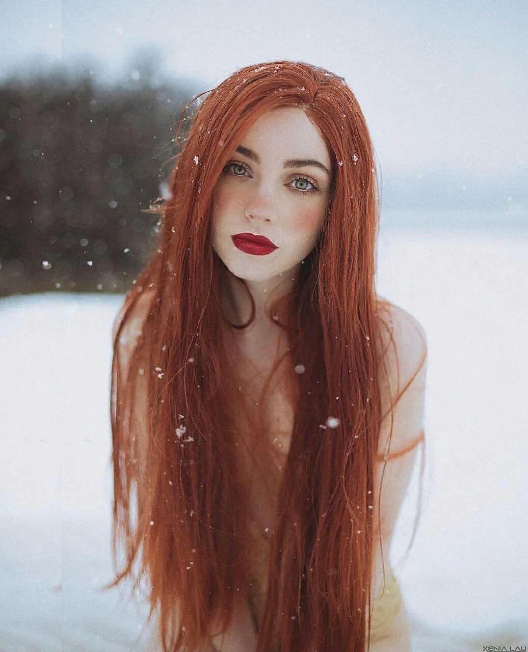Red Haired Woman in the Snow Looking Ahead with Calm Eyes