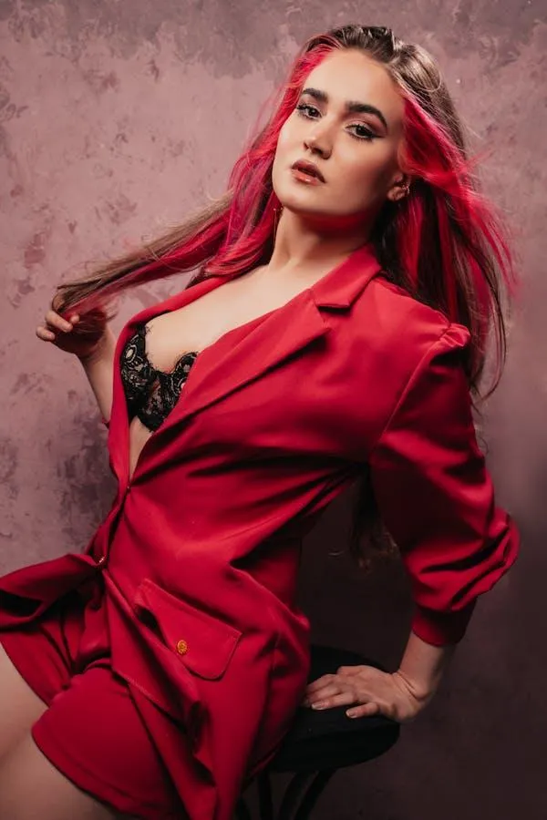 Red headed woman wearing a red outfit sitting on the stool