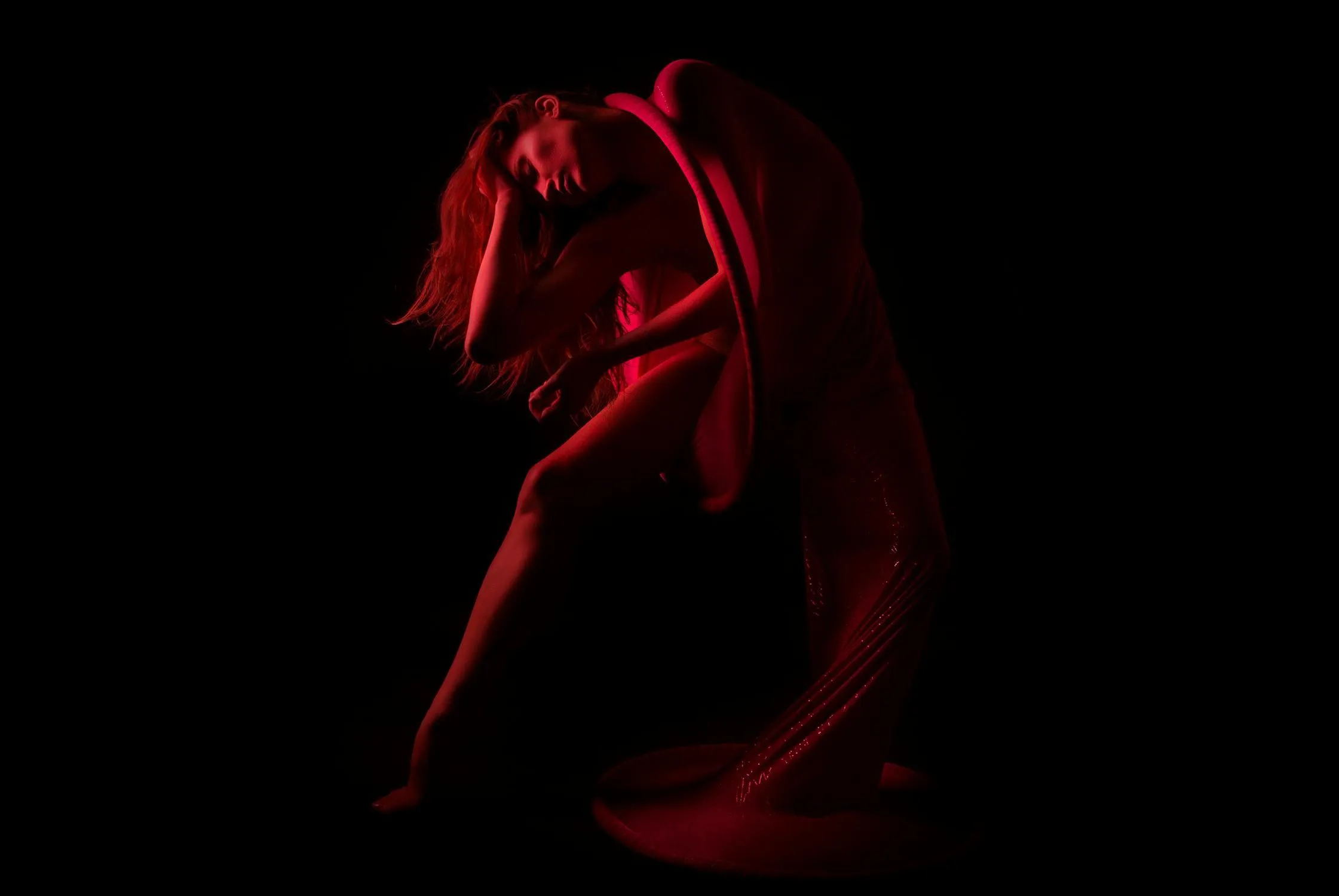 Red light silhouette of a woman in an expressive dance pose