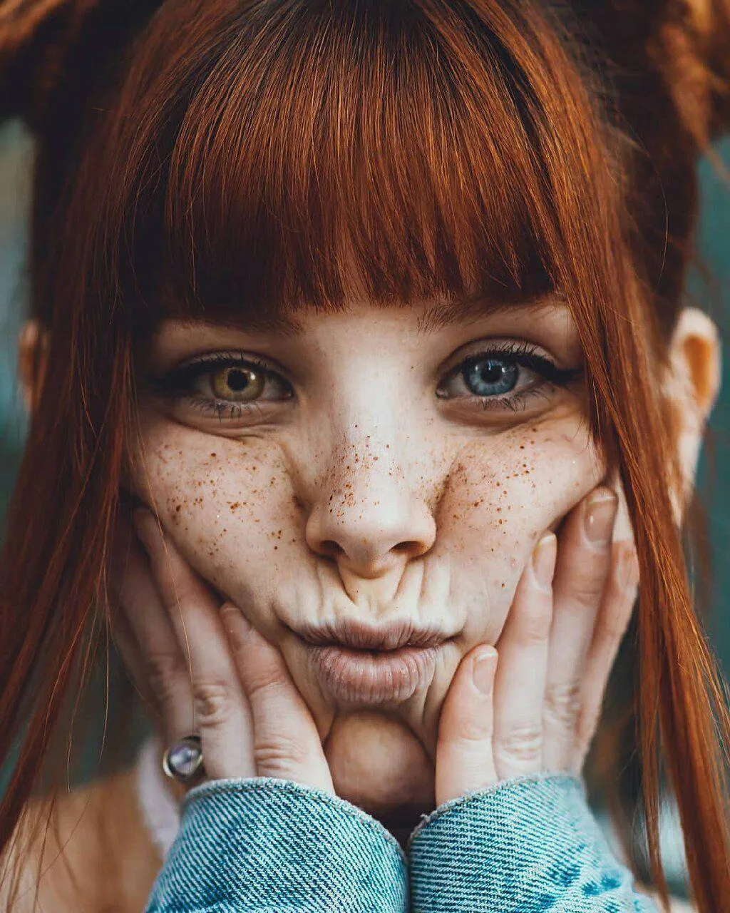 Redhead Girl with Freckles Poses Close Up in Soft Light