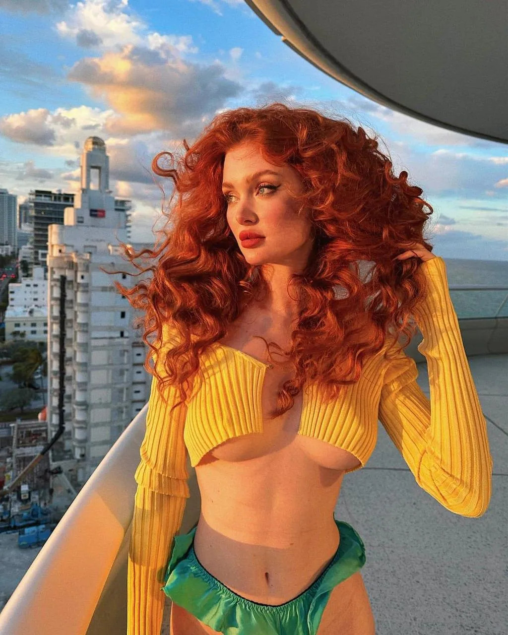 Redhead Woman in a Yellow Top Poses on High Rise Balcony