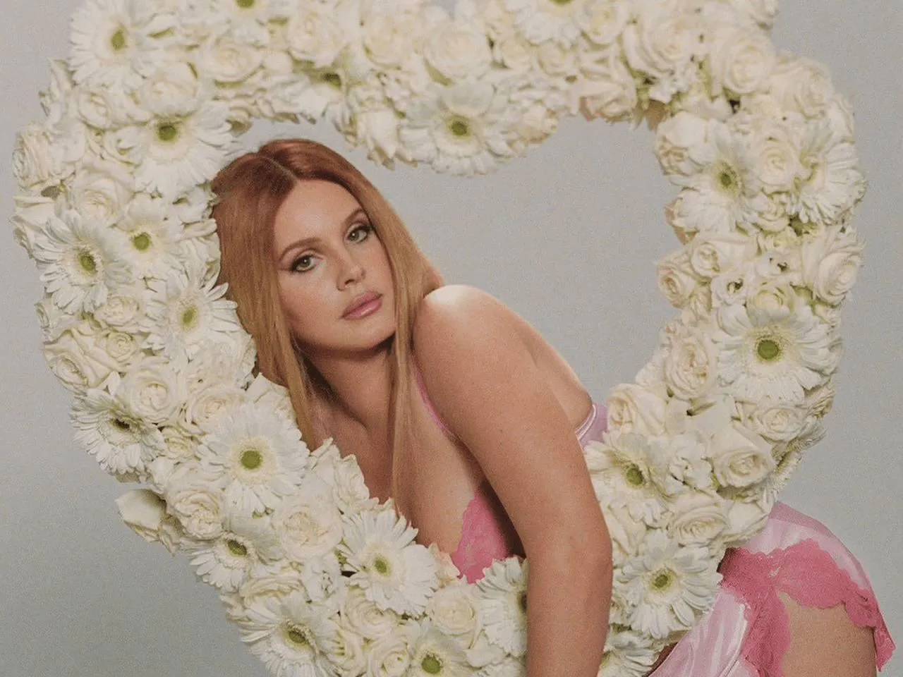 Redhead Woman Posing Inside a Large Heart of White Roses