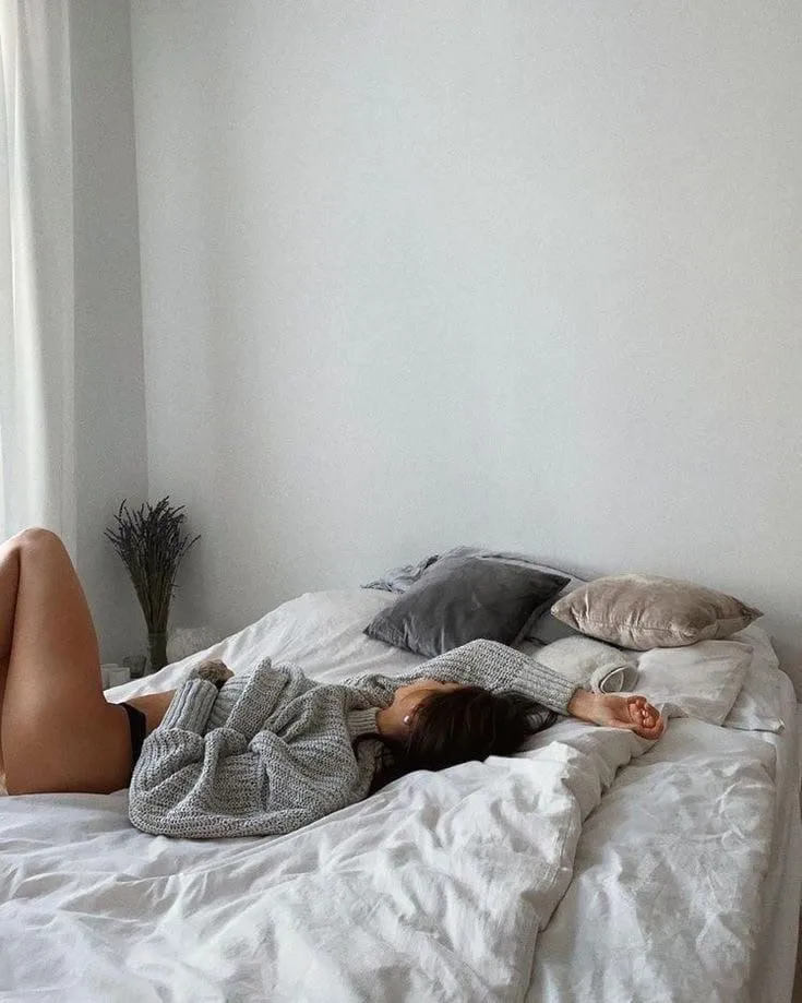 Relaxed woman lying on a bed in a cozy home atmosphere image