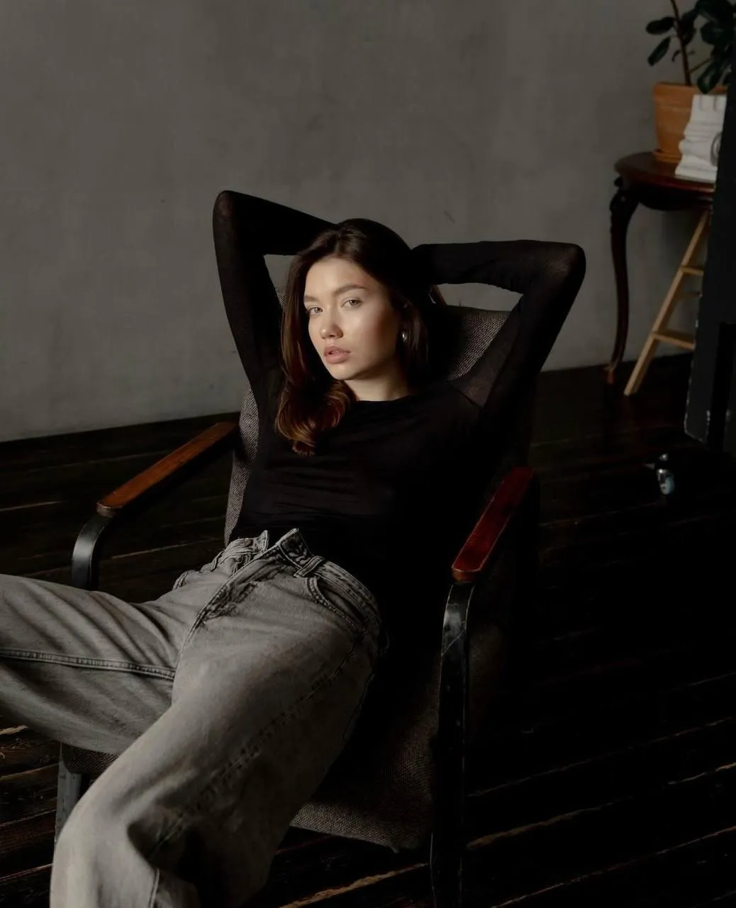 Relaxed young woman reclining in chair wearing casual jeans