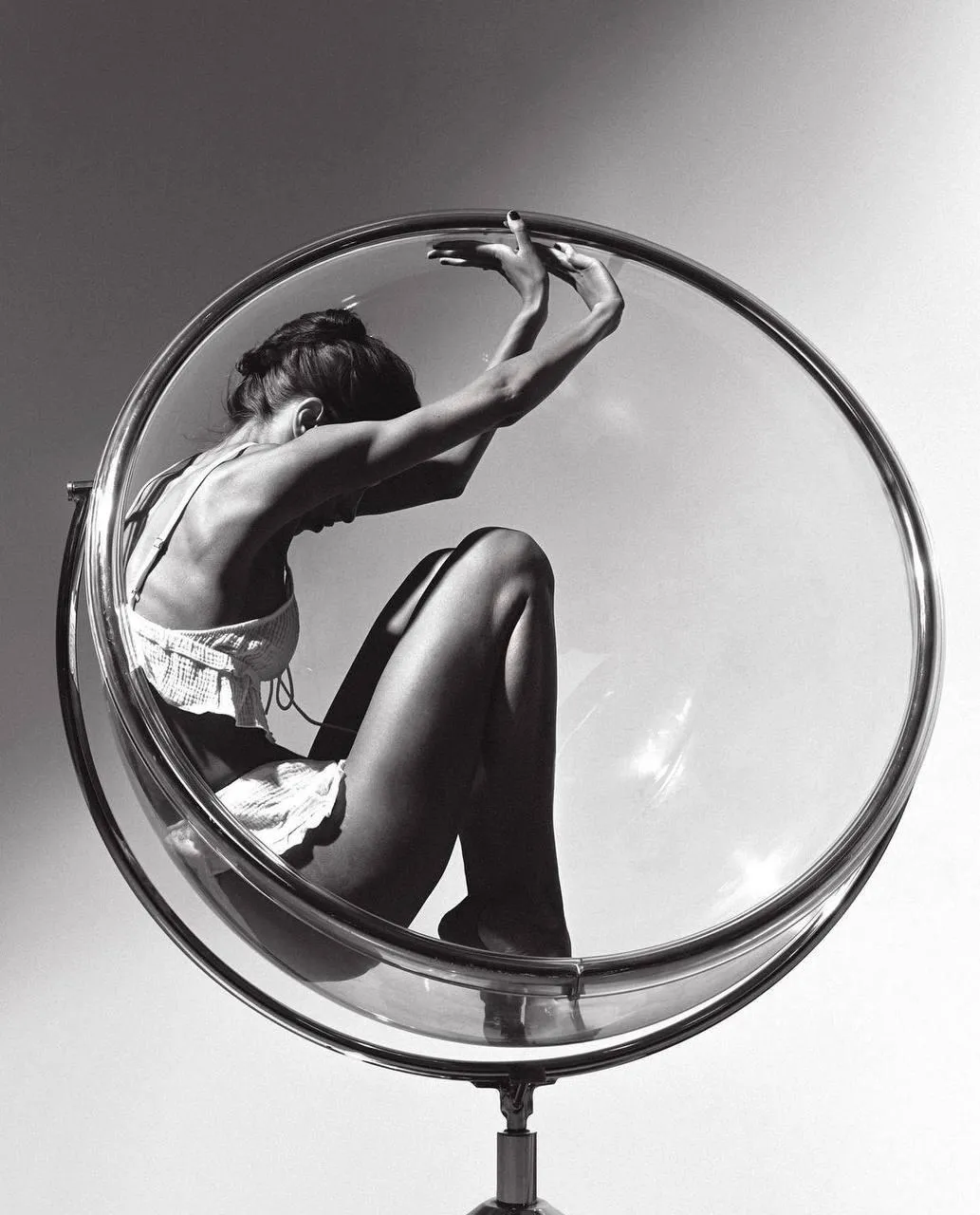 Silhouette of a Woman Sitting in a Transparent Hanging Chair