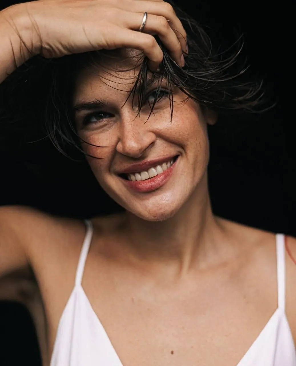 Smiling woman in a white top looking joyful and full of life