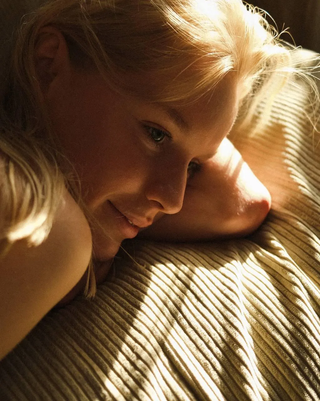 Soft Lit Woman Lying in a Bed with Golden Morning Light