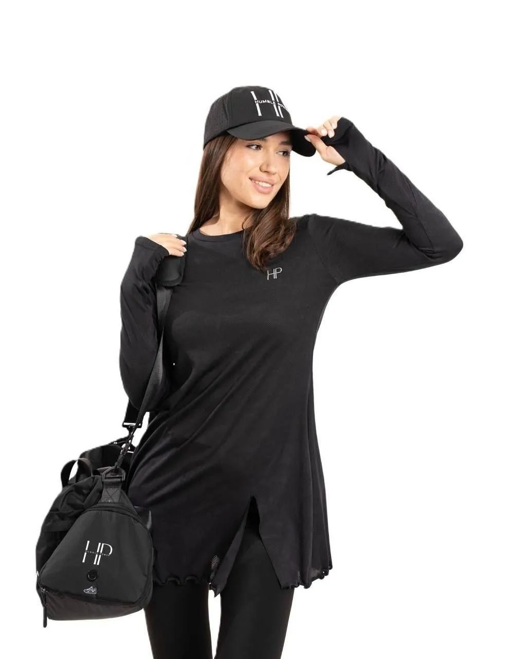 Sporty woman wearing a cap and a black hoodie with a handbag