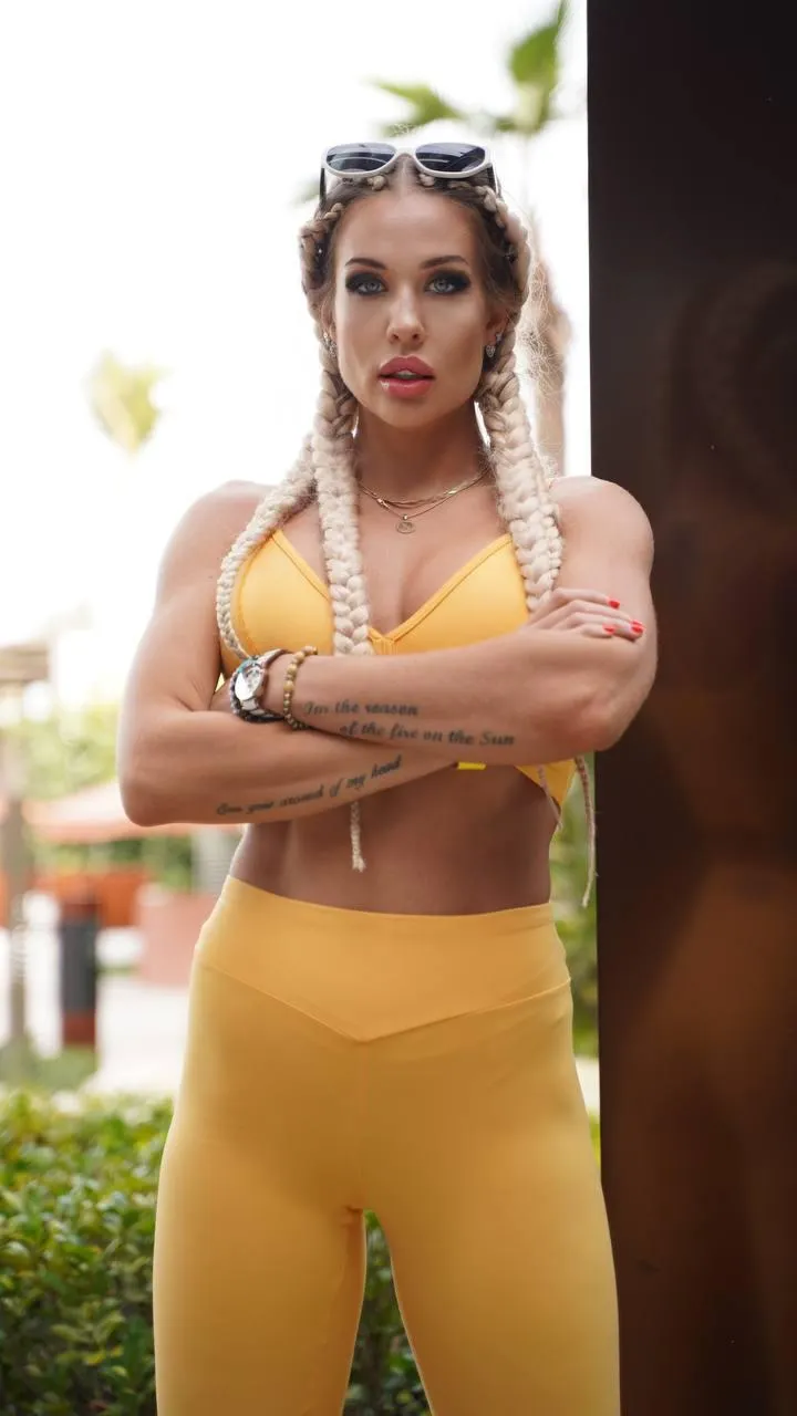 Strong woman in a golden attire posing with arms crossed