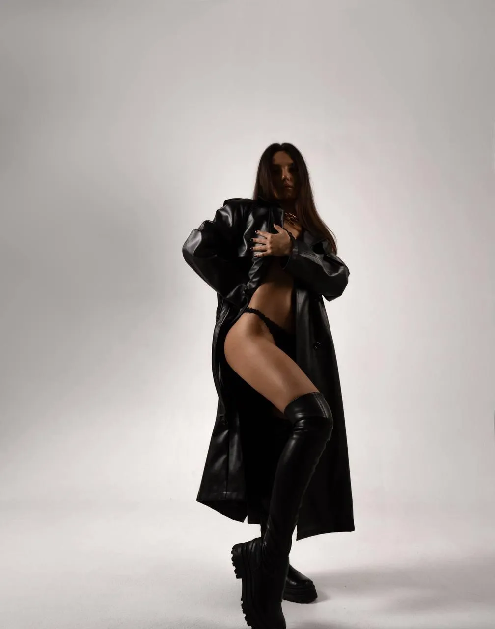 Stunning image of a woman with black coat standing in studio