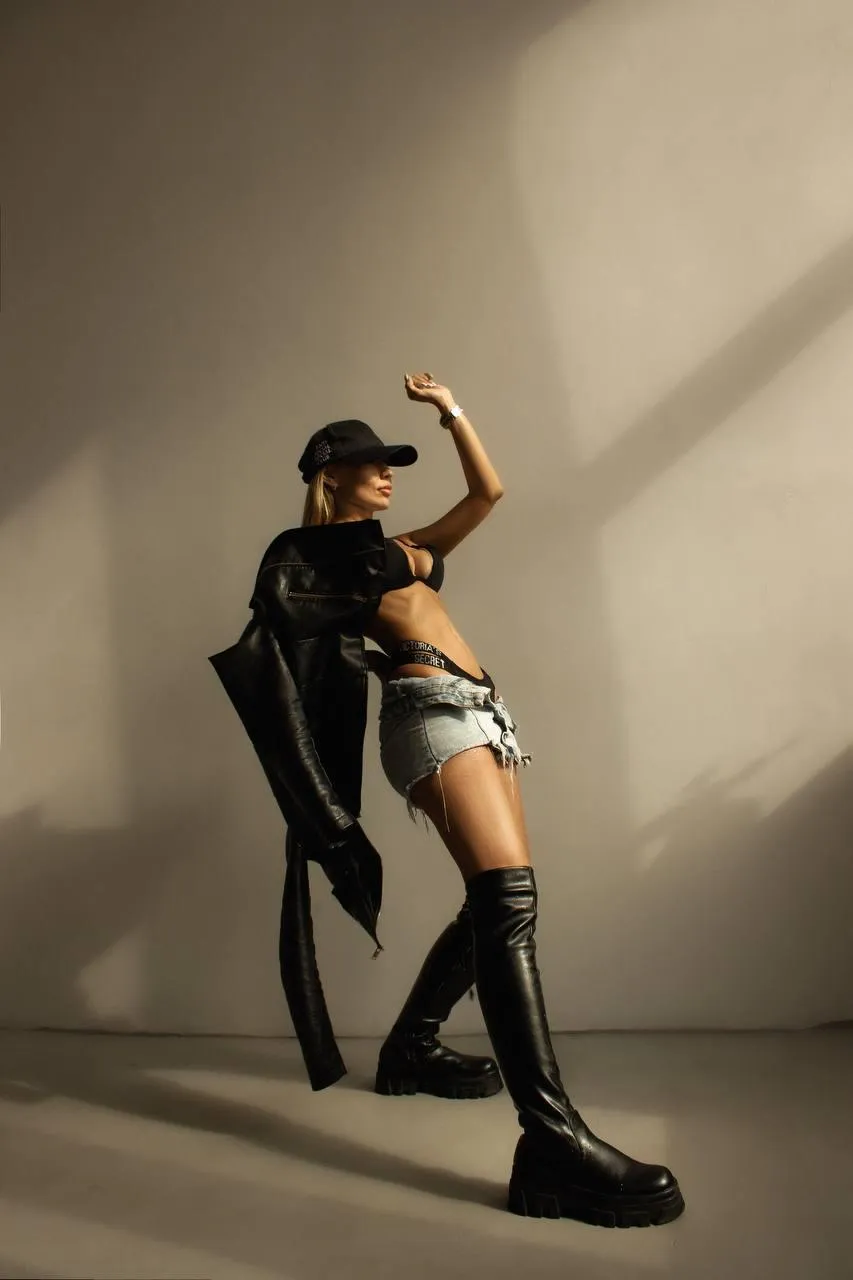Stunning pose of a woman in a black outfit in a studio image