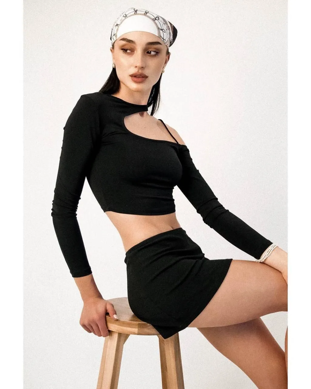 Stylish Woman in a Black Two Piece Outfit on White Backdrop