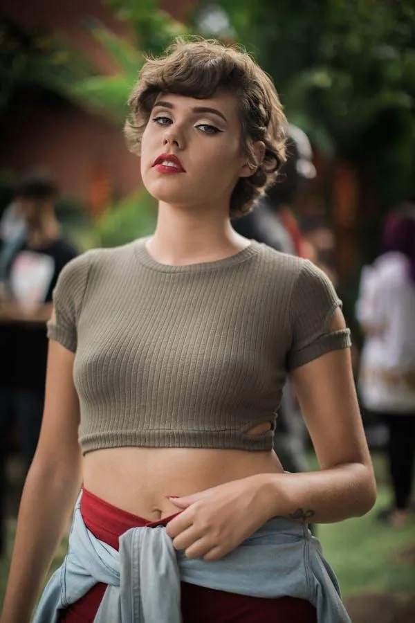 Stylish woman in a crop top and red pants with dark lipstick