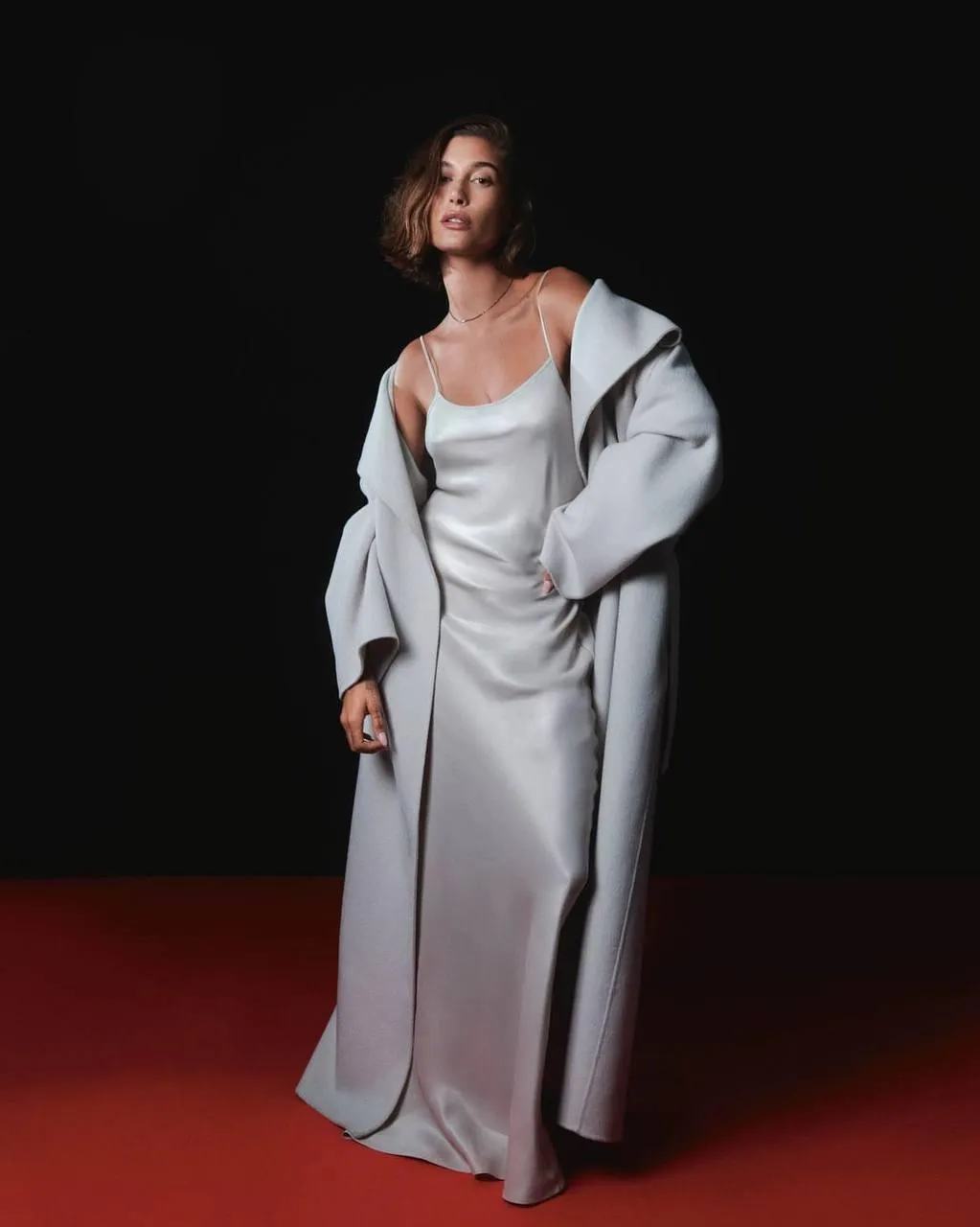 Stylish woman in a gray outfit standing on the red floor