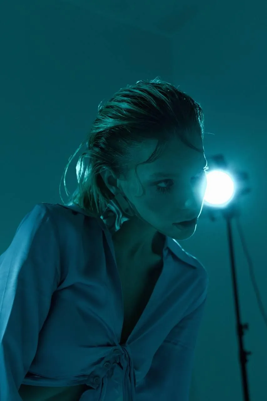 Stylish woman in a white outfit with a spotlight wallpaper