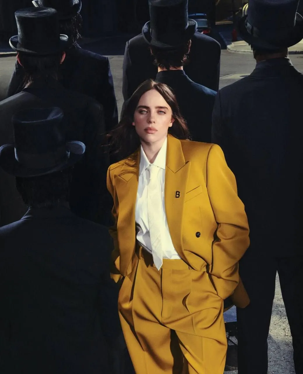Stylish woman in a yellow suit walks through the busy crowd