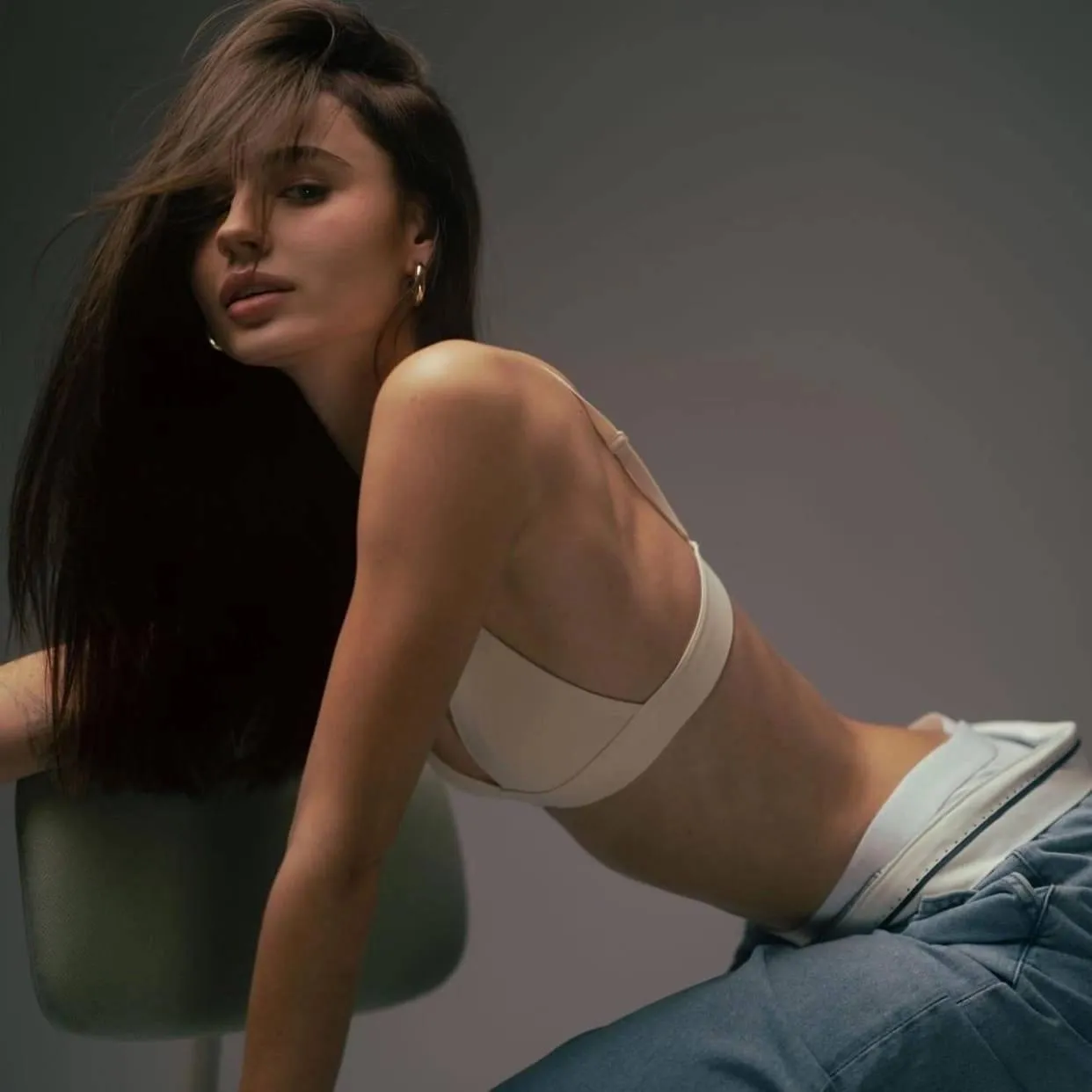 Stylish woman in jeans and a crop top posing indoors image