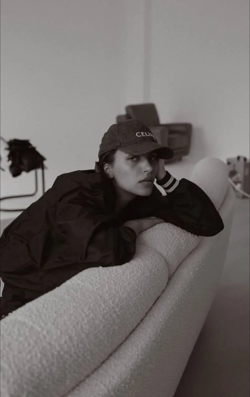 Stylish woman lounging casually on a sofa with a hat image
