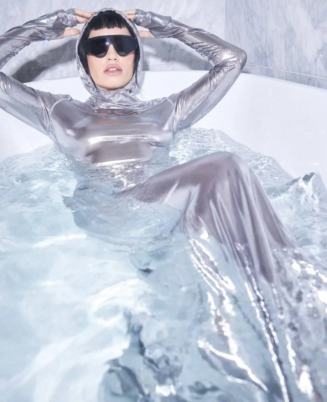 Stylish Woman Reclining in a Futuristic Silver Outfit Image