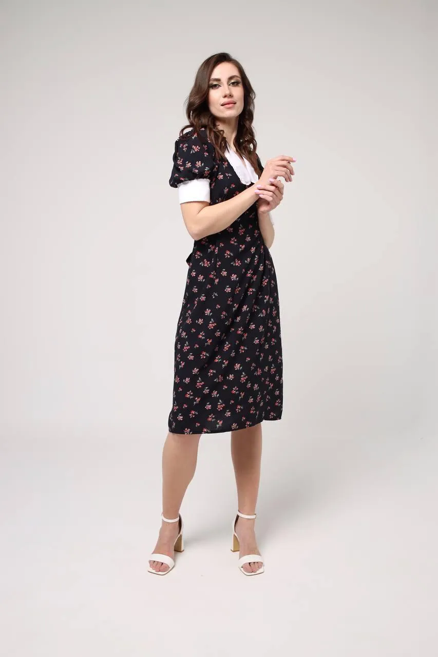 Stylish woman standing in the studio wearing a floral dress