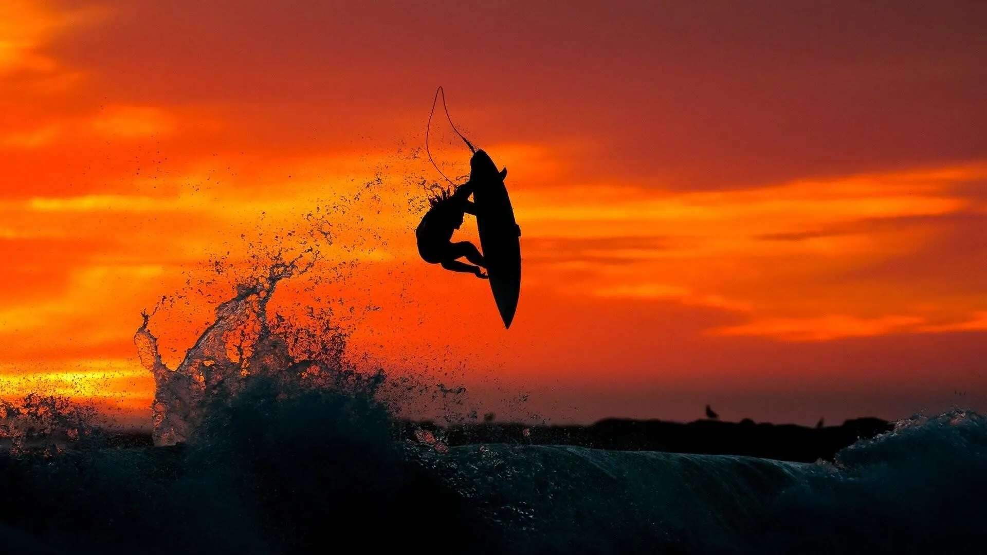Surfer Catching a Sunset Wave with Vibrant Sky in Background