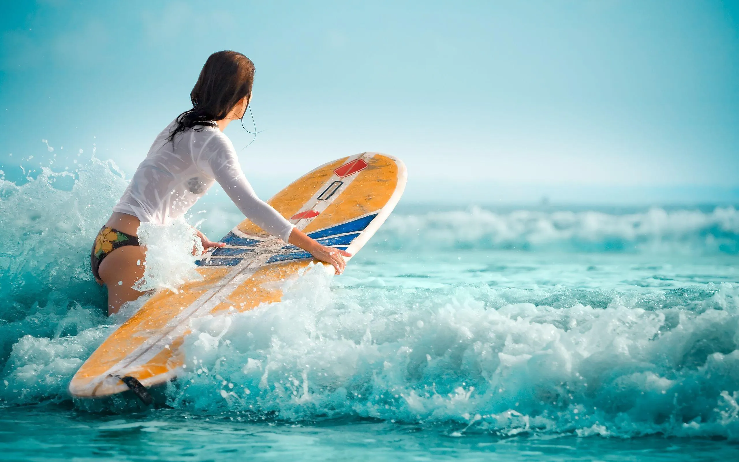 Surfer in a White Top Paddling Through Clear Ocean Waves