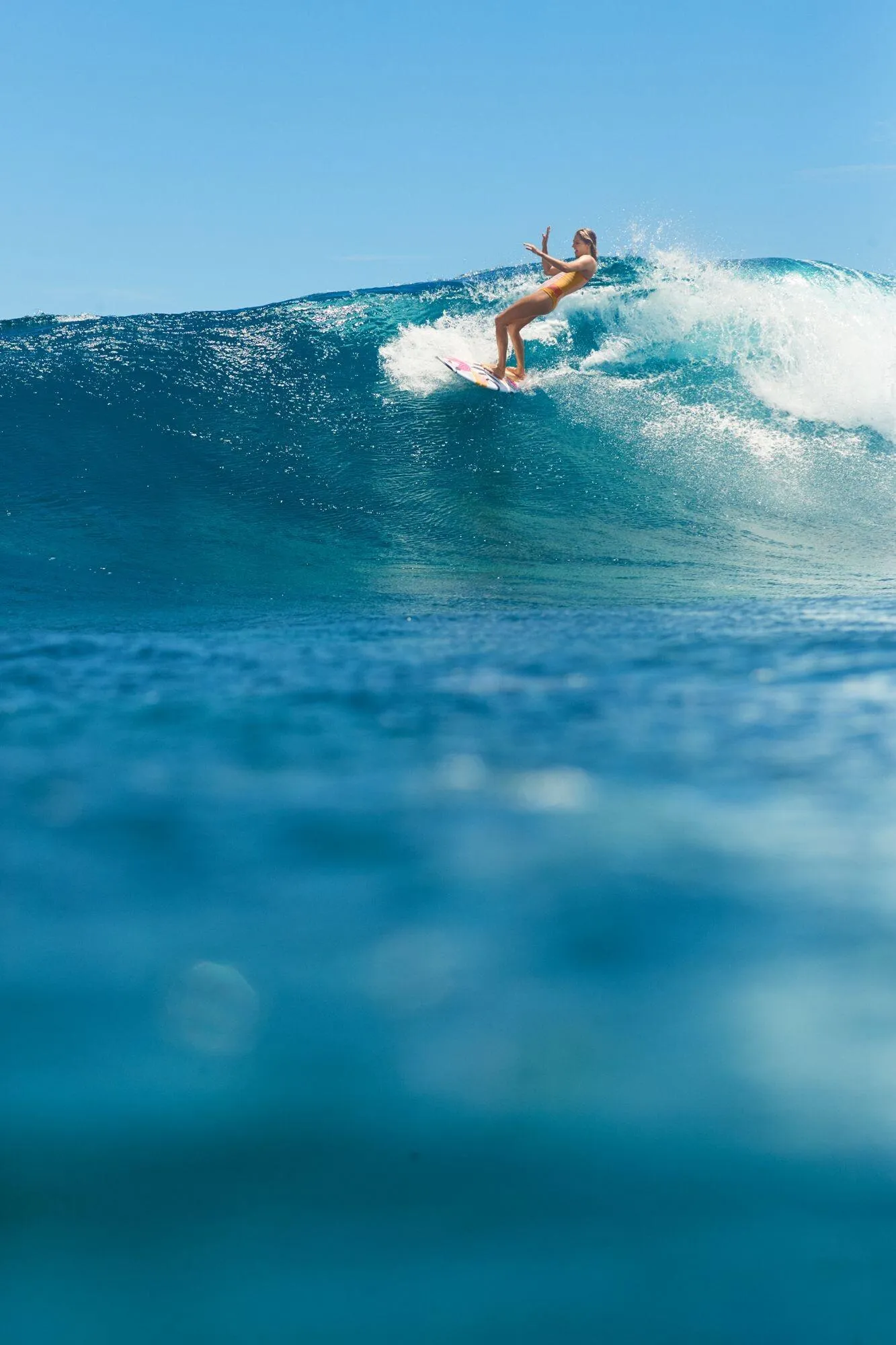 Surfer Riding a Powerful Blue Wave in Sunny Clear Water