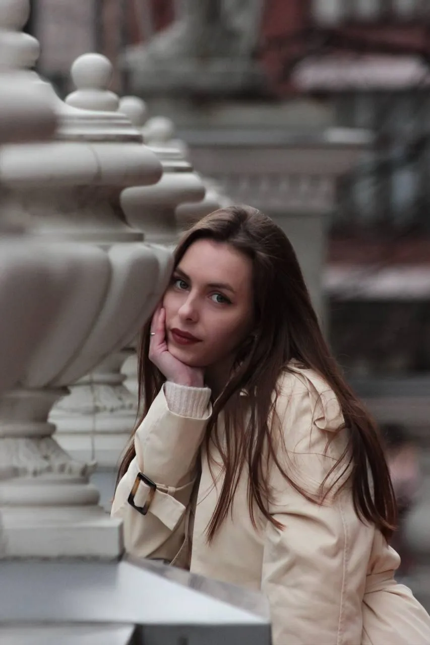Thoughtful woman leaning on railing with soft natural light