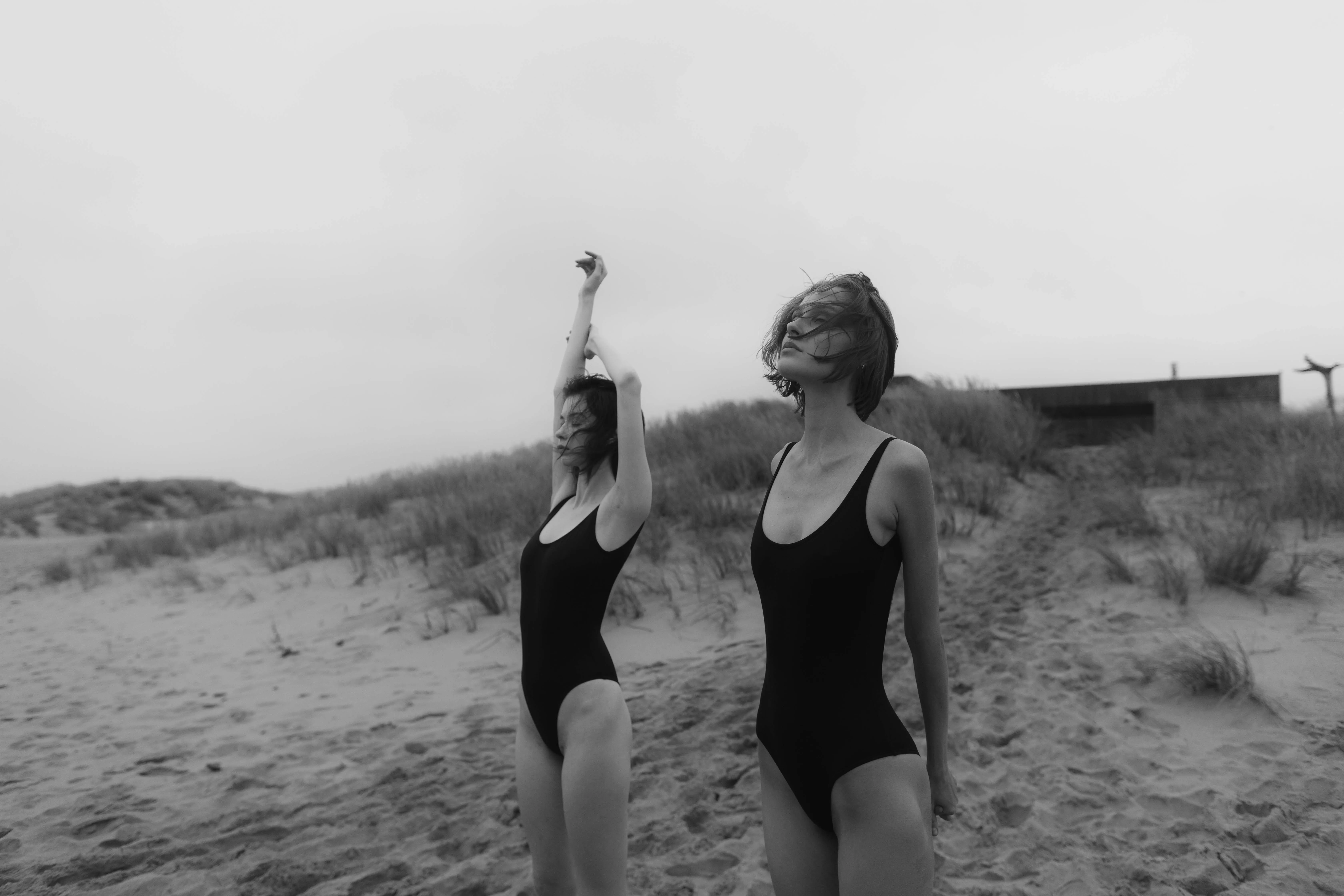 Two Women in a Swimsuit Walking on the Beach in Grayscale