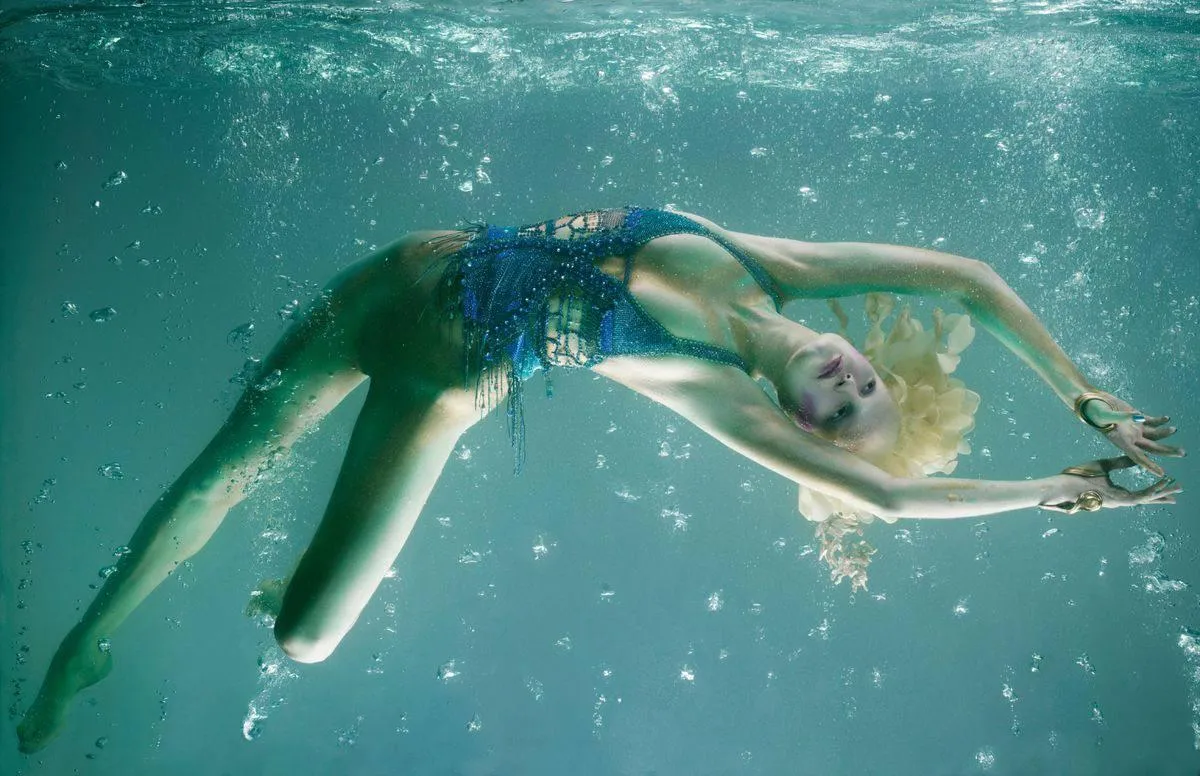 Underwater Photo of a Woman Swimming with Graceful Motion