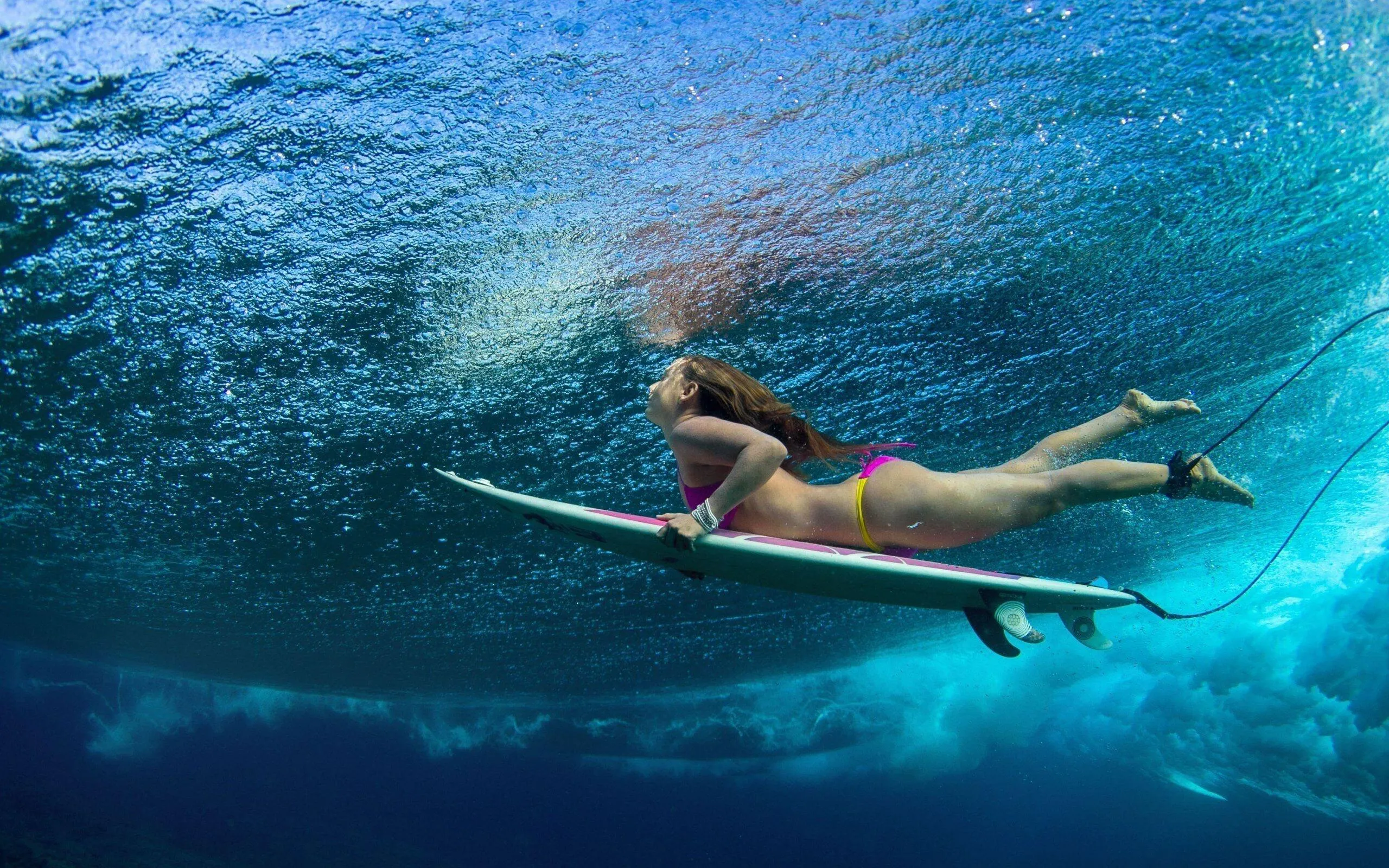 Underwater Shot of a Woman Surfing Beneath the Ocean Waves