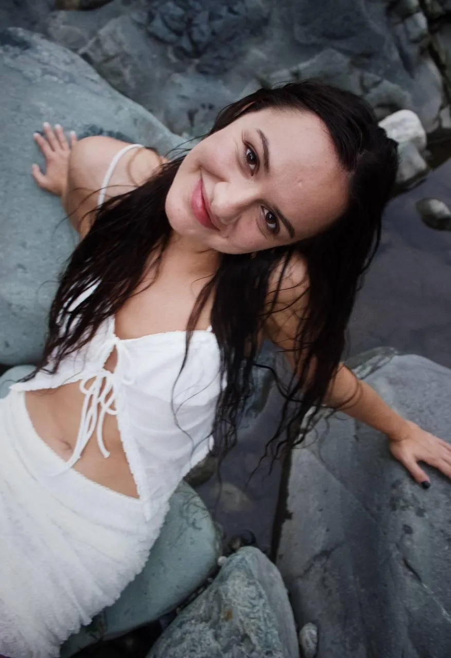 Wet Look Near Rocks with Joyful Expression And Flowing Dress