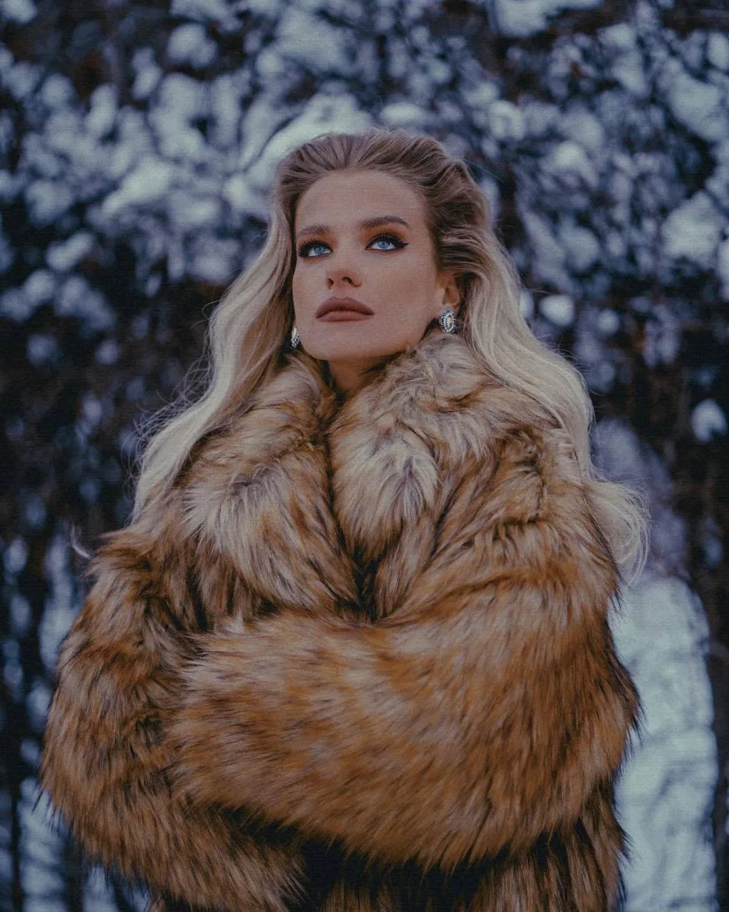 Winter Fashion Model in a Fur Coat Posing in a Snowy Forest