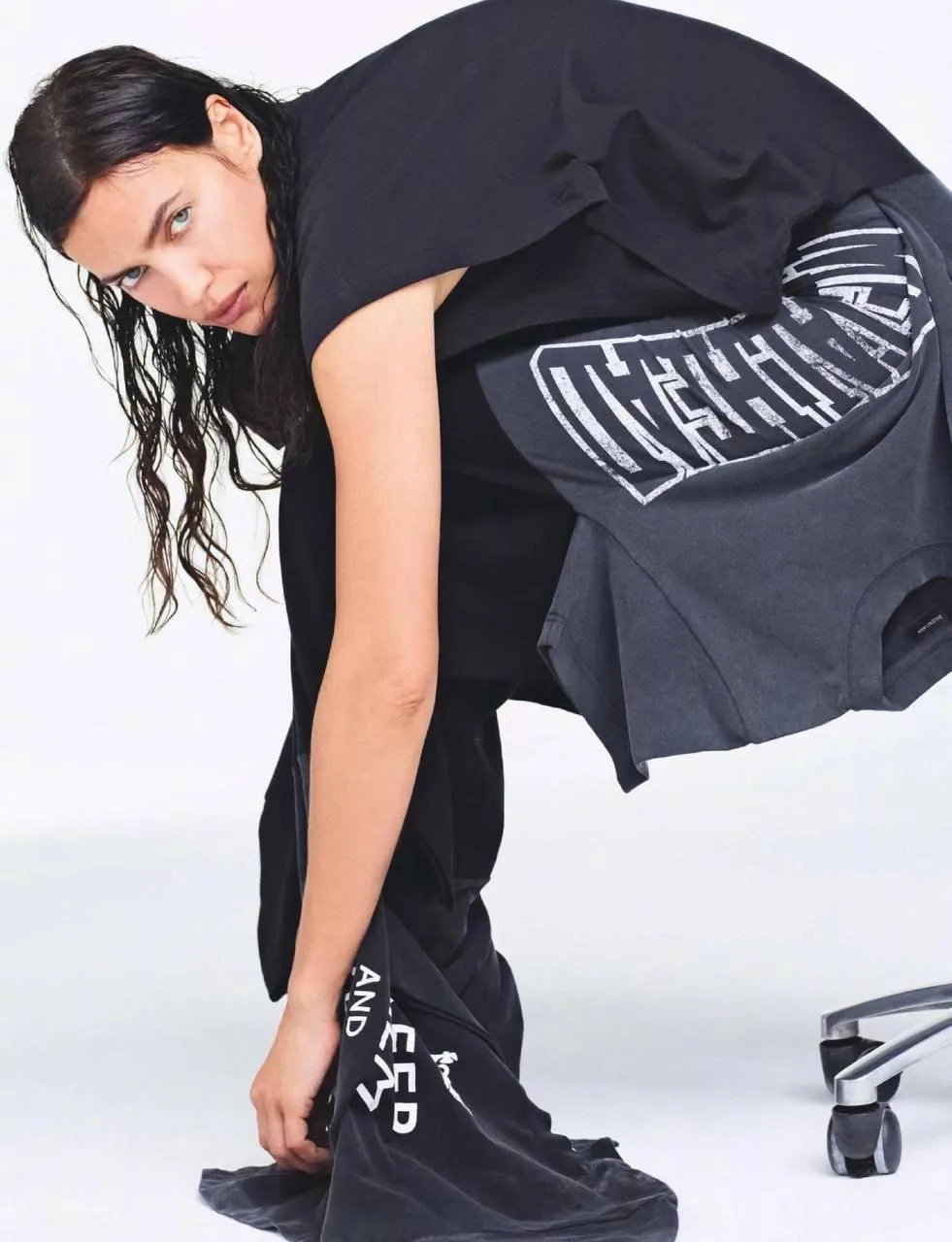Woman Bending in Black Outfit Posing Against White Backdrop