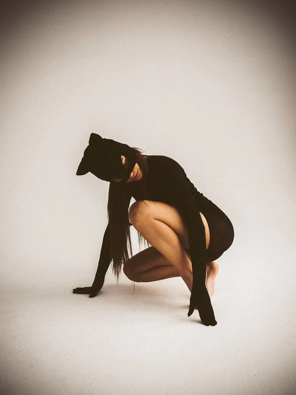 Woman Dressed in a Black Cat Costume Crouching on the Floor