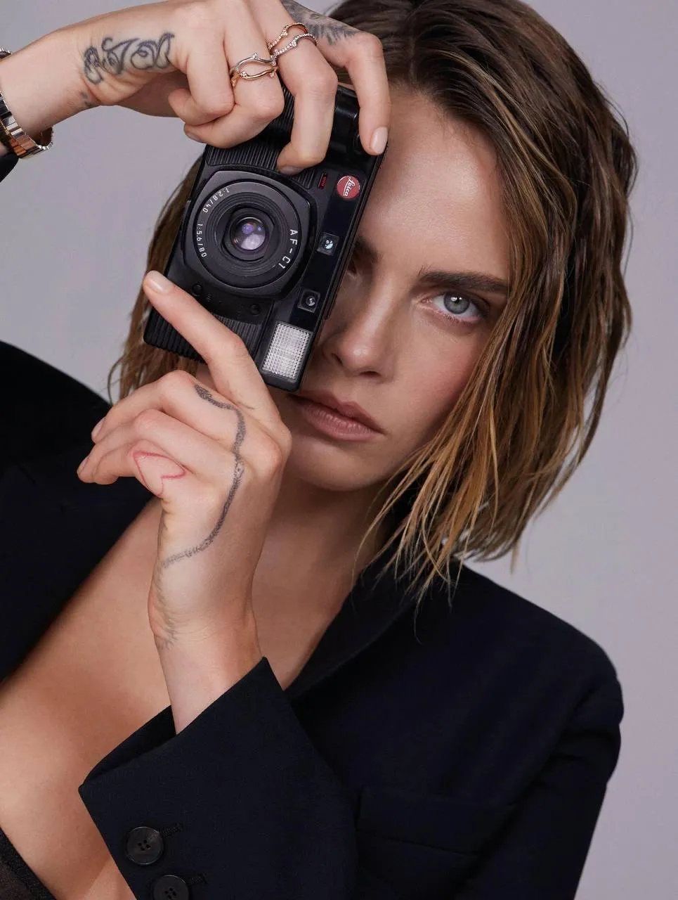 Woman Holding a Camera Close To Her Face in Studio Portrait
