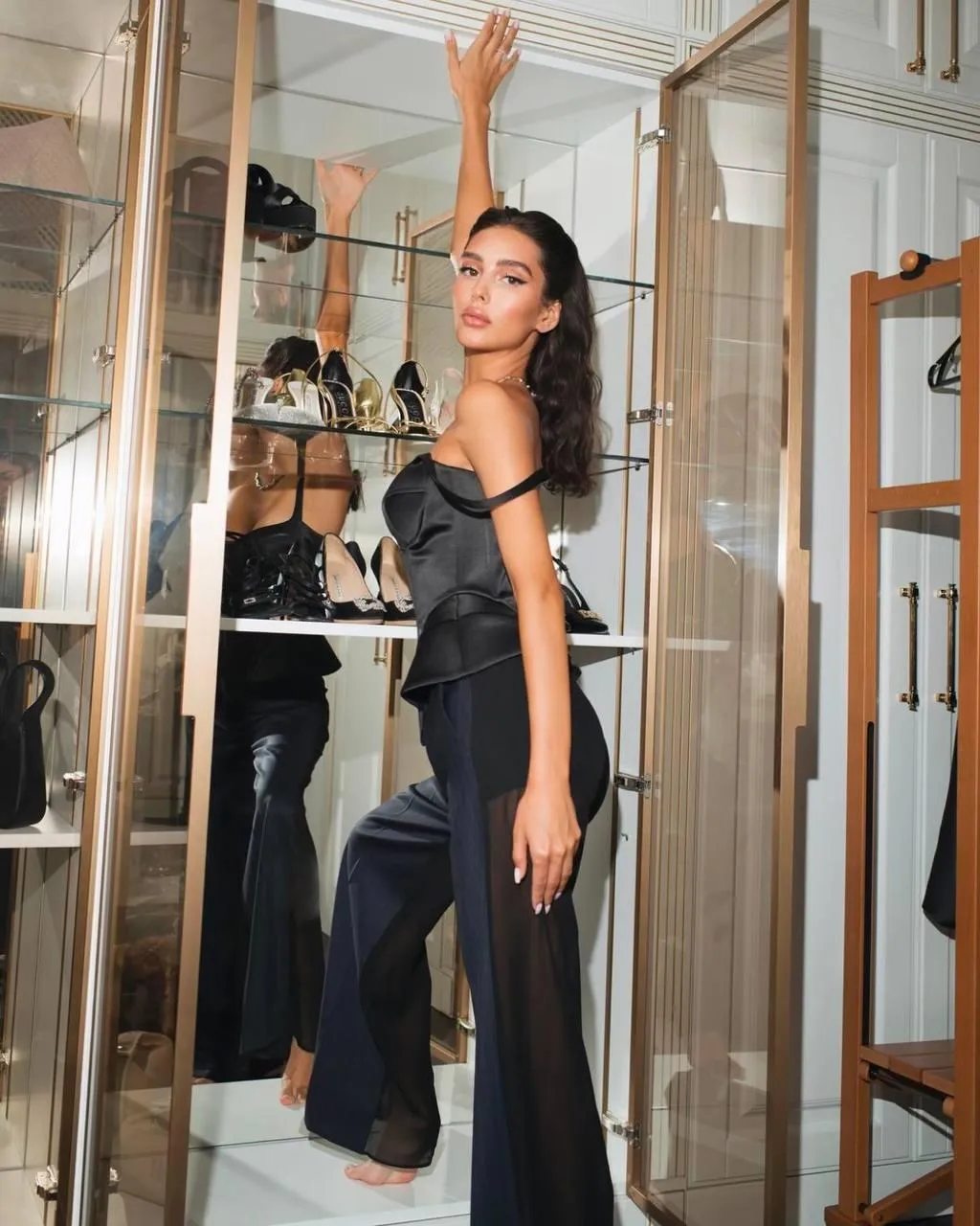 Woman in a Black Dress Posing Inside Mirrored Dressing Room