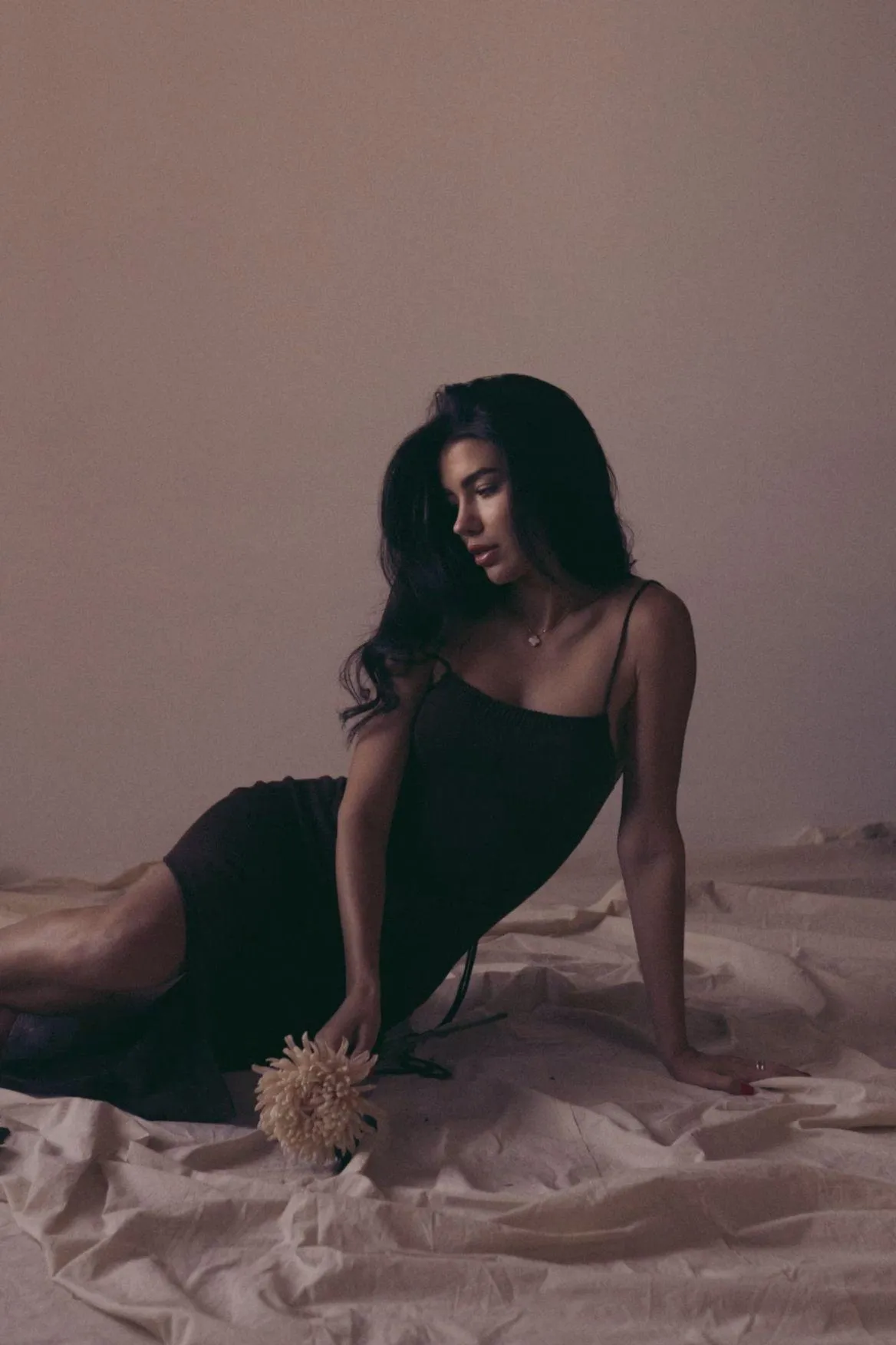 Woman in a Black Dress Sitting on Floor with Soft Lighting