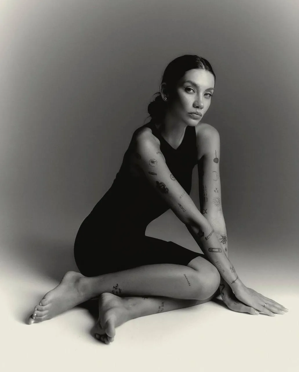 Woman in a black dress sitting on the floor with soft grace