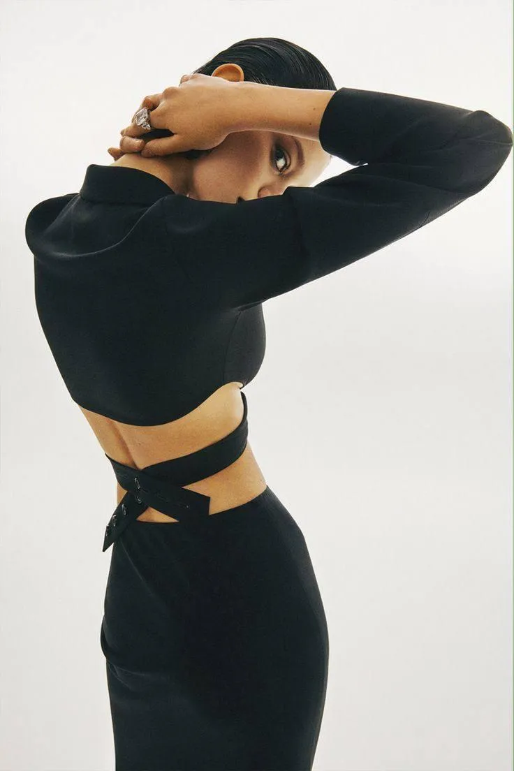 woman in a black outfit band on her neck looking intensely