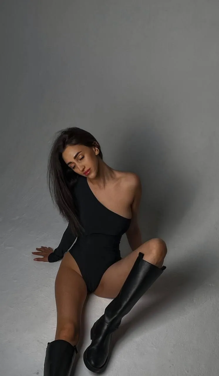 Woman in a black outfit sitting on the studio floor image