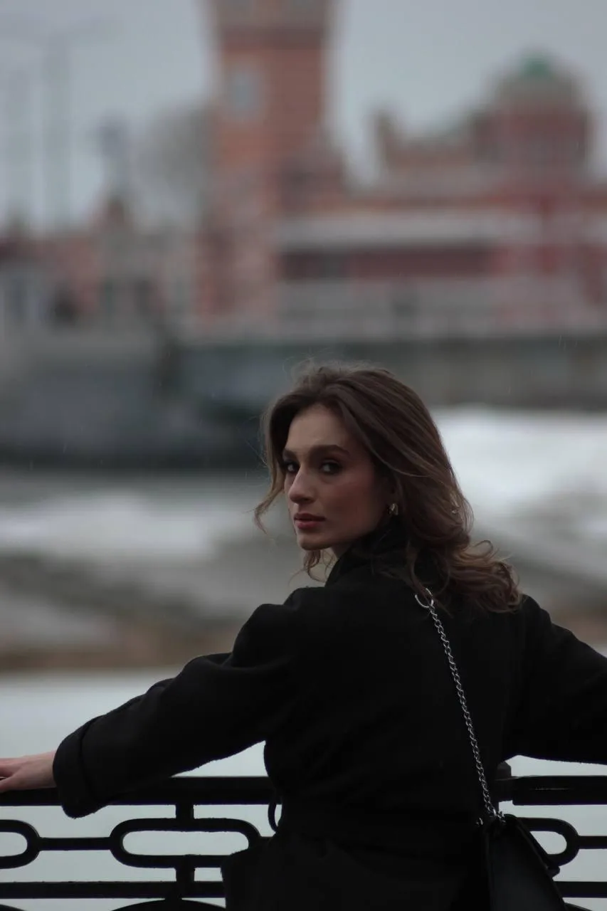 Woman in a black outfit standing in the cityscape wallpaper