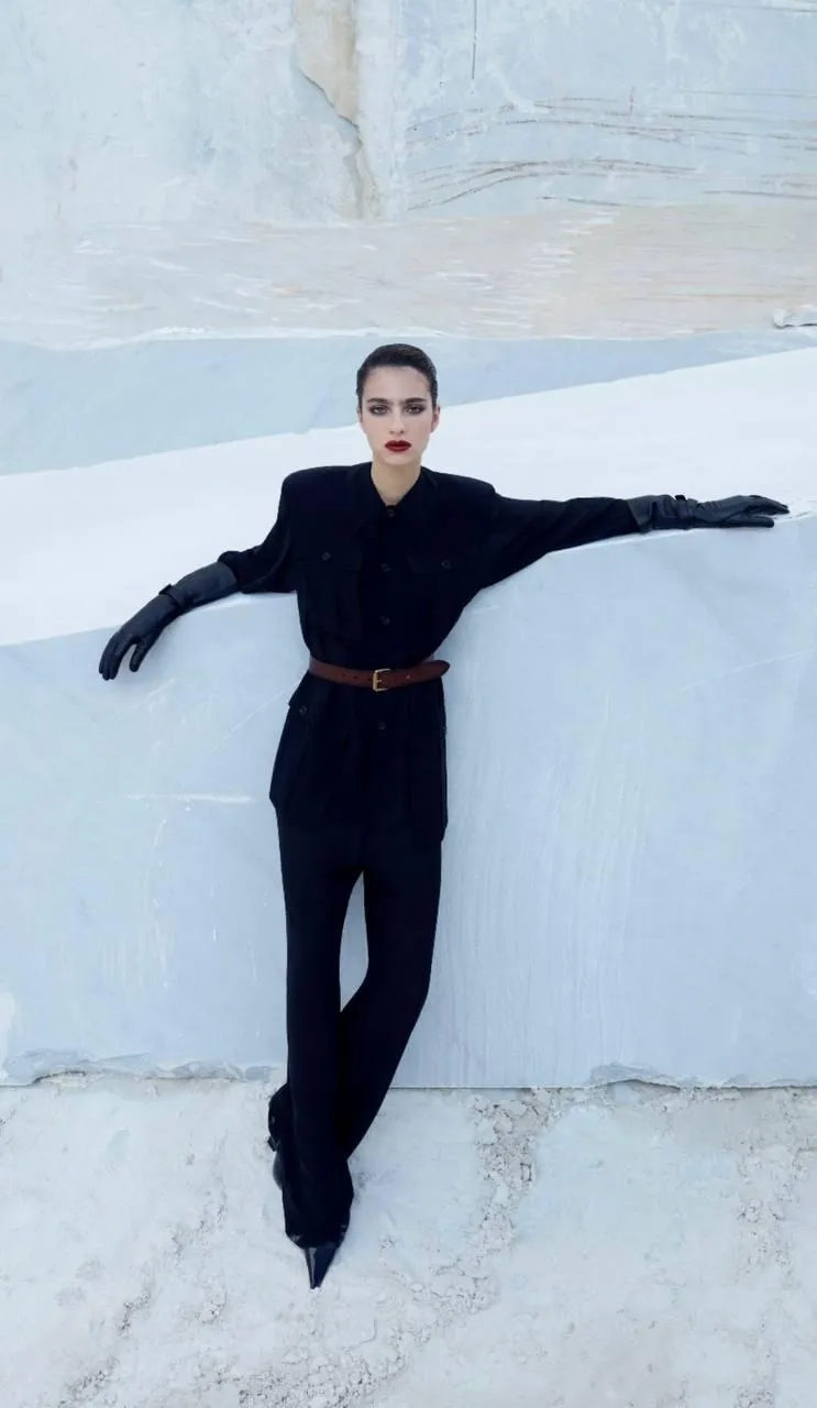 Woman in a black outfit stretching arms in a snowy setting