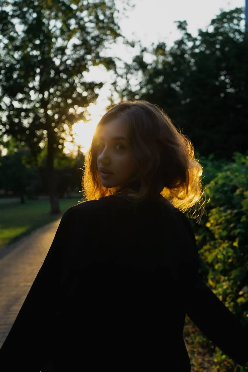 Woman in a black outfit walking at golden hour on a path
