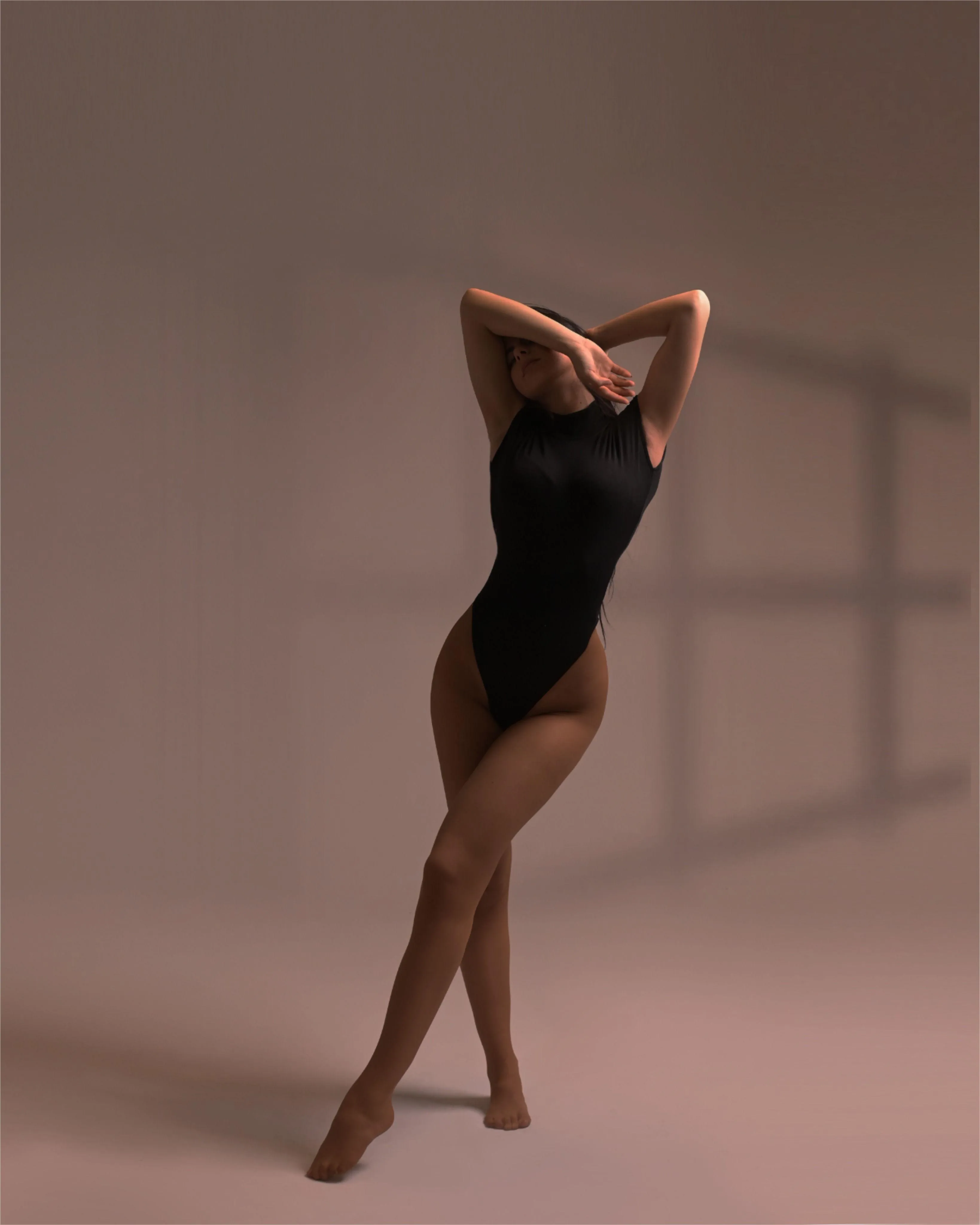 Woman in a Black Swimsuit Posing Confidently in Soft Studio