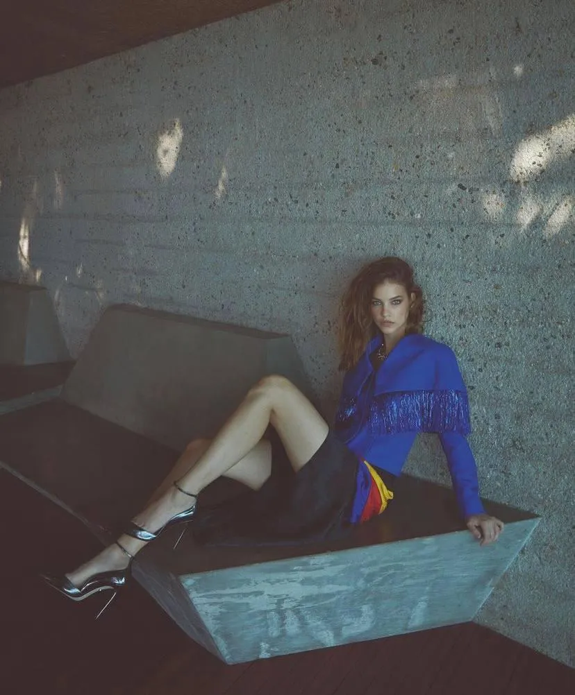 Woman in a Blue Outfit Poses on a Sofa in a Modern Setting
