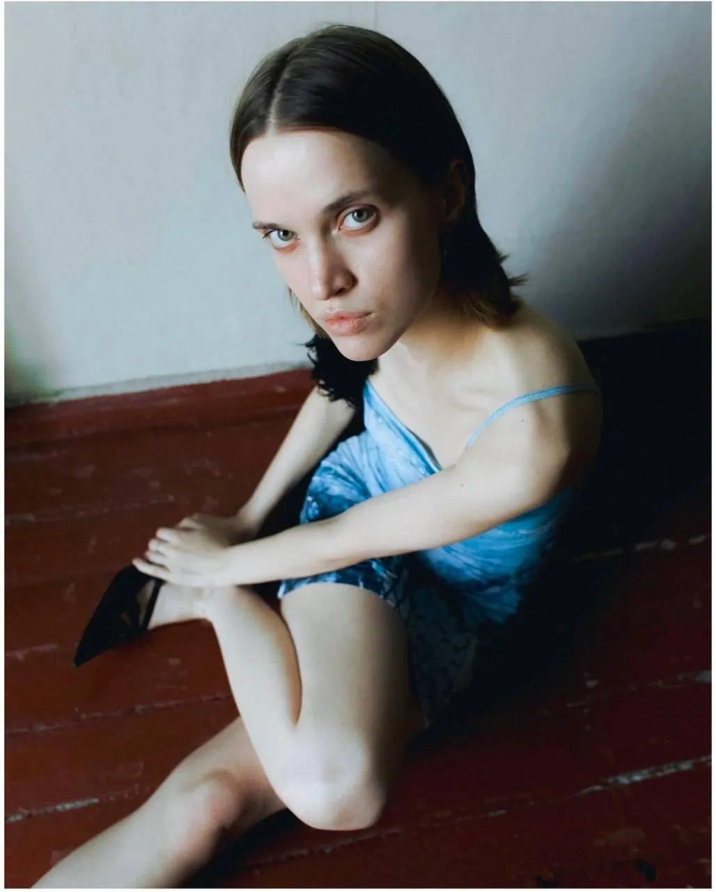Woman in a denim dress sitting on a wooden floor Wallpaper